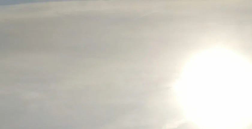 Imagem da energia e presença divina da Mãe Maria, com a visão de um coração iridescente iluminado pela luz de uma abertura no céu.